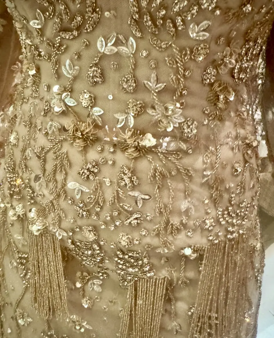 Close-up of gold sequin leaves, bead florets and beaded fringe on tulle
