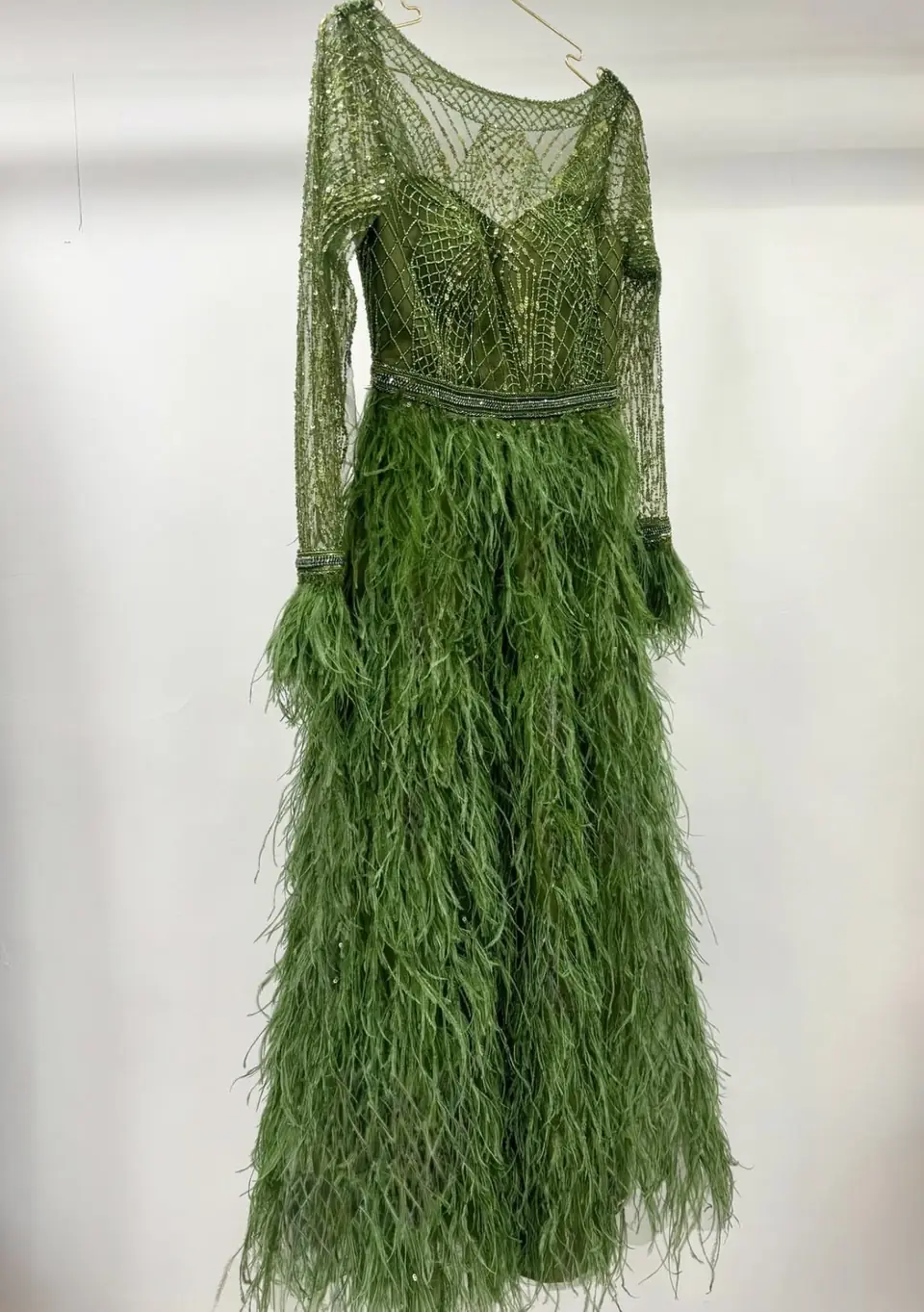 Olive green gown with a geometric beaded bodice and ostrich feather skirt