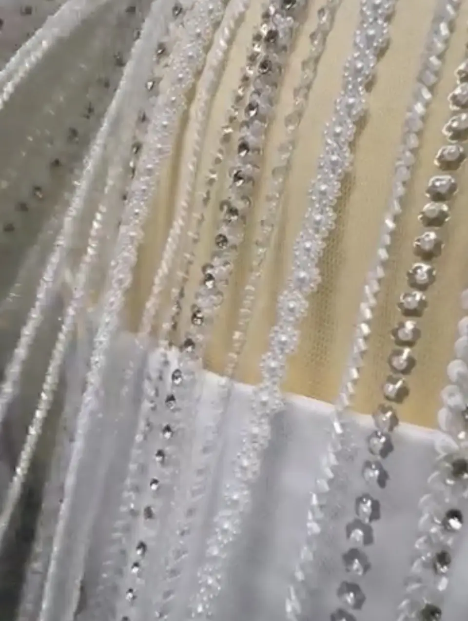 Close-up of pearl, crystal and sequin beaded strands on a sheer cape