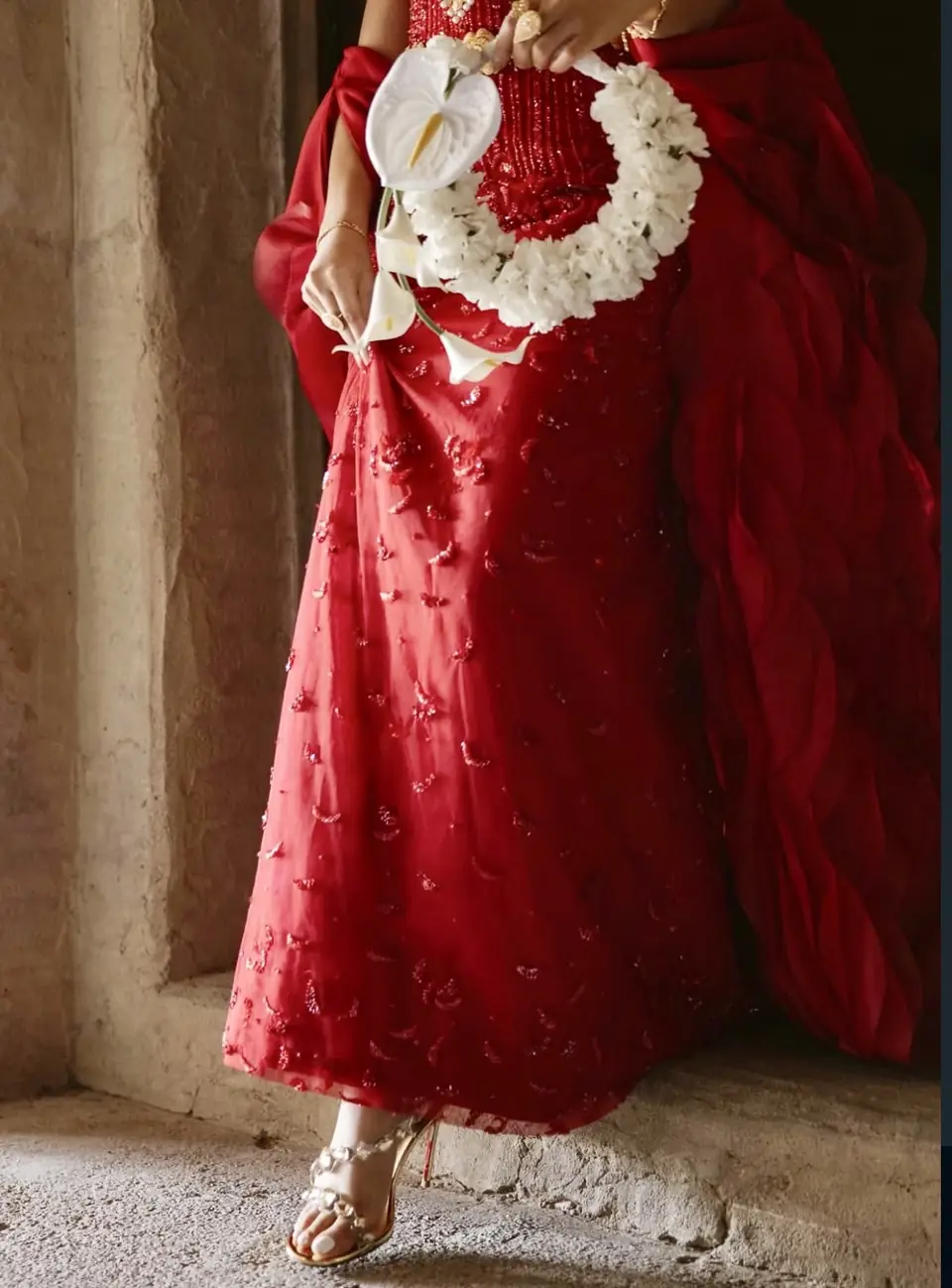 Red beaded tulle gown and organza cape with a white wreath bouquet