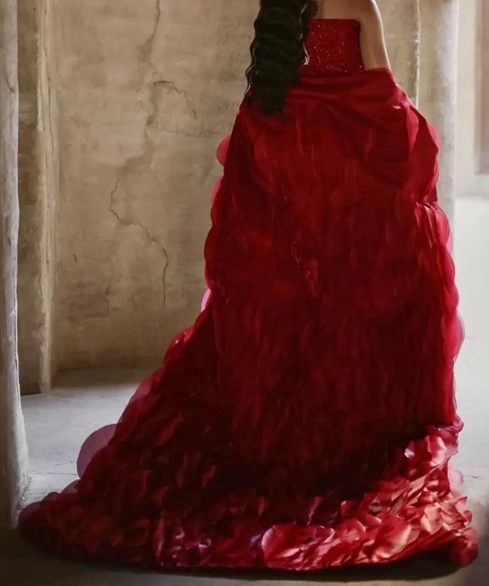 Back view of a red organza cape with layered petal train