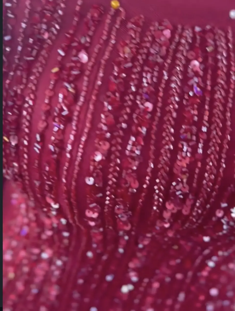 Macro of red sequin and bugle-bead embroidery lines