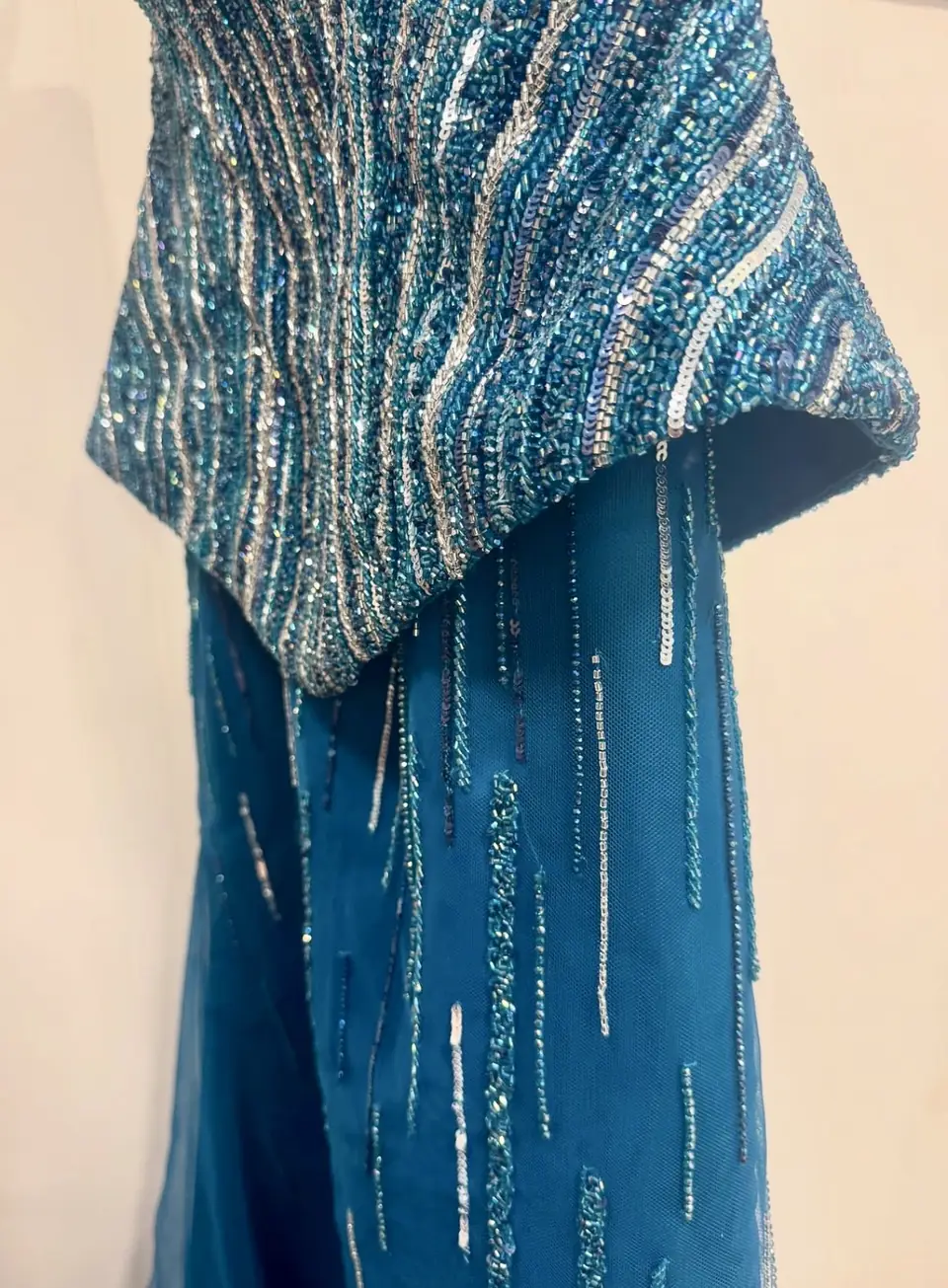 Teal beaded peplum over a tulle skirt with falling bead lines